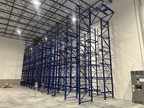 Tall blue pallet rack frames in a new warehouse